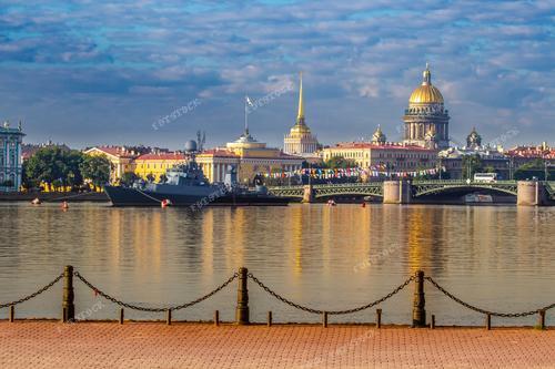 Это захватывающее фото представляет собой летний день в Санкт-Петербурге, украшенный морским парадом. Величественные военные корабли проходят мимо Собора Исаакия, создавая потрясающий пейзаж. Эта фотография олицетворяет величие российской военной силы и прекрасный летний день на берегах Невы.